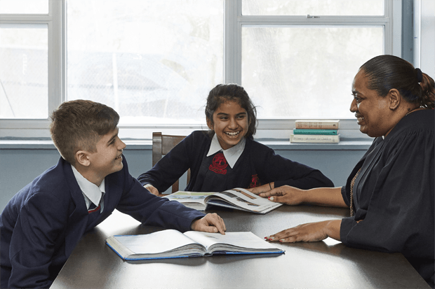 a teacher teaching two elementary students at King's College School a private school serving students in the Caledon, Brampton, Orangeville and Bolton areas